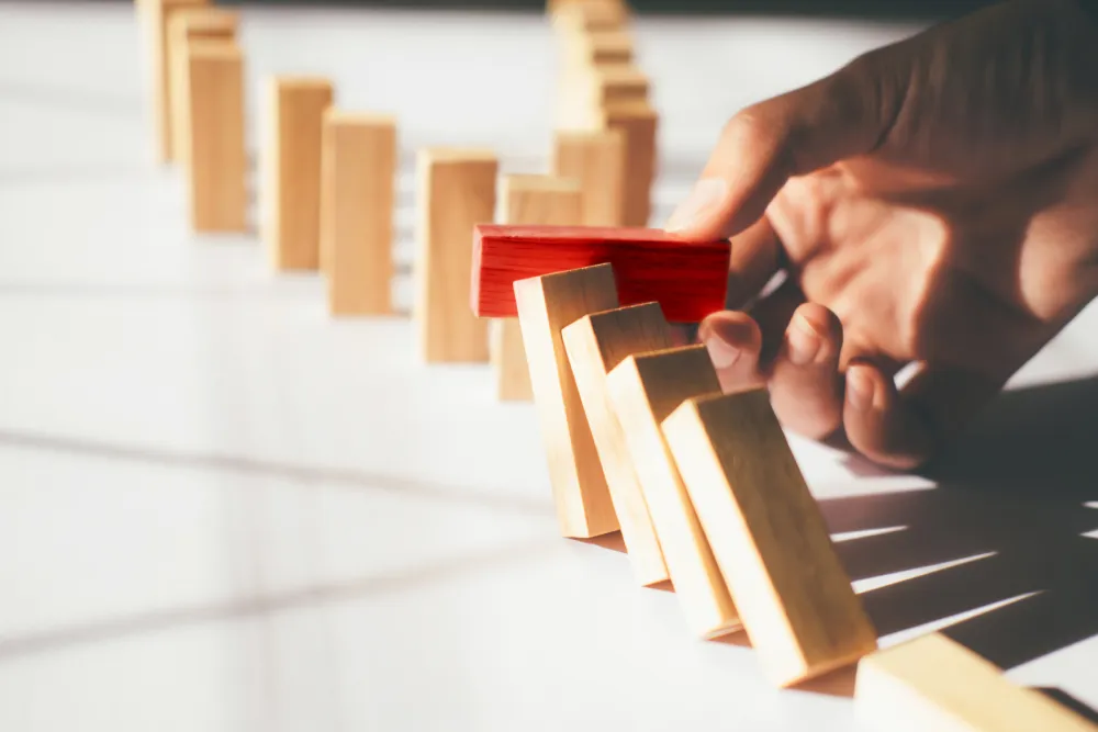 Businessman hand stop dominoes continuous toppled or risk with copyspace. Business risk, strategy and planing concept idea.